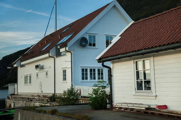 Casa de madeira tradicional norwegian que está em um gramado e montanhas no fundo. Casa típica norueguesa. casa típica norwegian com grama no telhado — Fotografia de Stock