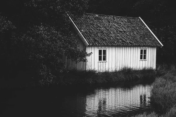 Casa tradițională din lemn norvegiană în picioare pe un gazon și munți în fundal. Casa tipică norvegiană. tipic norvegian casa cu iarbă pe acoperiș — Fotografie, imagine de stoc