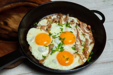 Kızarmış yumurta tavada yapardı. Otlar ve biber ile terbiyeli bir tavada pastırmalı kızarmış yumurta
