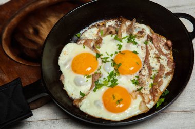 Kızarmış yumurta tavada yapardı. Otlar ve biber ile terbiyeli bir tavada pastırmalı kızarmış yumurta