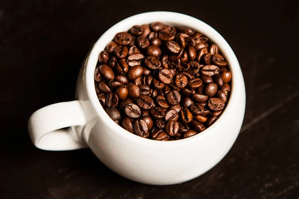 Una taza de café llena de granos de café. Primer plano . — Foto de Stock