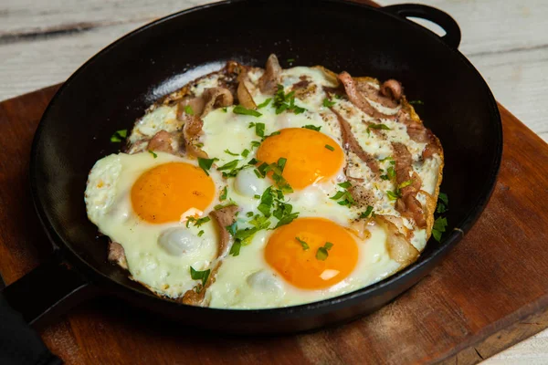 Kızarmış yumurta tavada yapardı. Otlar ve biber ile terbiyeli bir tavada pastırmalı kızarmış yumurta