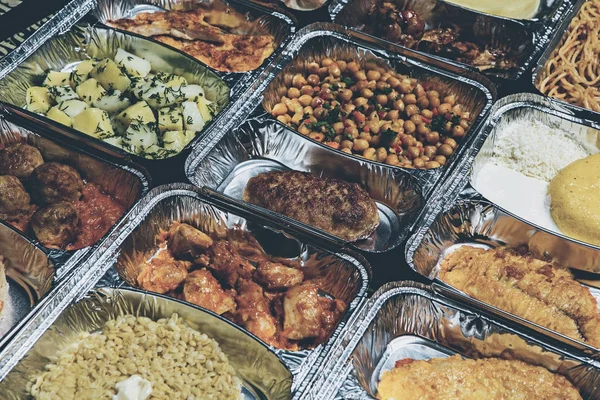 Healthy lunch in aluminum foil package. Top view. Lunch box with food ready to go for work or school. grilled vegetables and chicken meat.