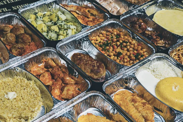 Healthy lunch in aluminum foil package. Top view. Lunch box with food ready to go for work or school. grilled vegetables and chicken meat.