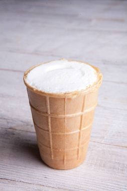 Gözleme Kupası'nda dondurma kaşık toz. Beyaz ahşap ve mavi arka plan üzerinde gözleme, dondurma. Gözleme kase lezzetli dondurma