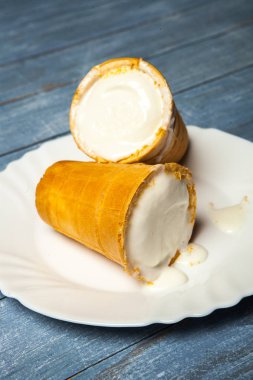 Gözleme Kupası'nda dondurma kaşık toz. Beyaz ahşap ve mavi arka plan üzerinde gözleme, dondurma. Gözleme kase lezzetli dondurma