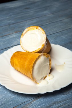 Gözleme Kupası'nda dondurma kaşık toz. Beyaz ahşap ve mavi arka plan üzerinde gözleme, dondurma. Gözleme kase lezzetli dondurma