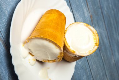 Gözleme Kupası'nda dondurma kaşık toz. Beyaz ahşap ve mavi arka plan üzerinde gözleme, dondurma. Gözleme kase lezzetli dondurma