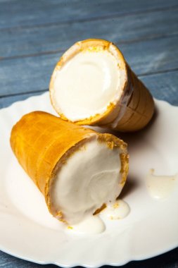 Gözleme Kupası'nda dondurma kaşık toz. Beyaz ahşap ve mavi arka plan üzerinde gözleme, dondurma. Gözleme kase lezzetli dondurma