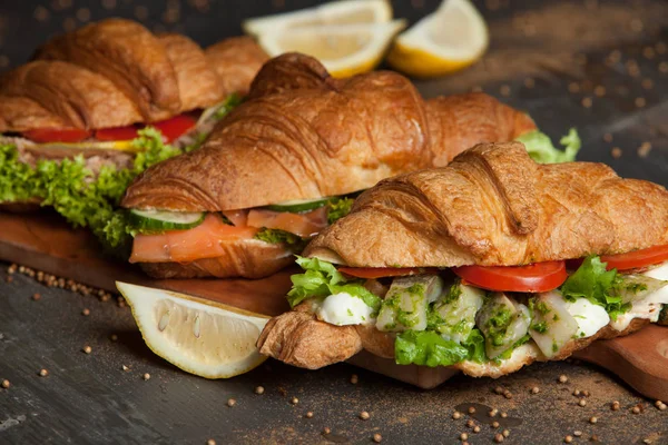 Kruvasan sandviç üzerinde ahşap kurulunda görev yapmaktadır. Kruvasan yumurta, eritilmiş peynir, maydanoz, tavuk jambon, füme somon ile