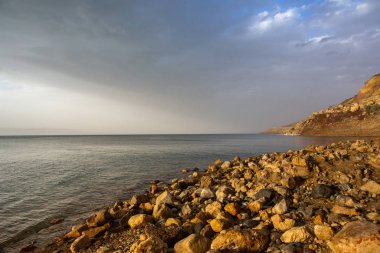 Ürdün 'de gün batımında Ölü Deniz kıyısı manzarası. Gün batımında tuz kristalleri. Mineral yapıları olan ölü deniz manzarası.