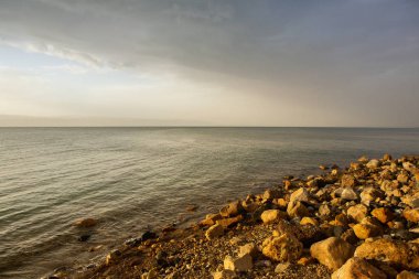 Ürdün 'de gün batımında Ölü Deniz kıyısı manzarası. Gün batımında tuz kristalleri. Mineral yapıları olan ölü deniz manzarası.