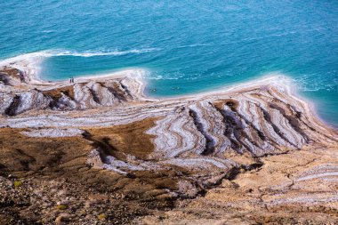 Ürdün 'de gün batımında Ölü Deniz kıyısı manzarası. Gün batımında tuz kristalleri. Mineral yapıları olan ölü deniz manzarası.