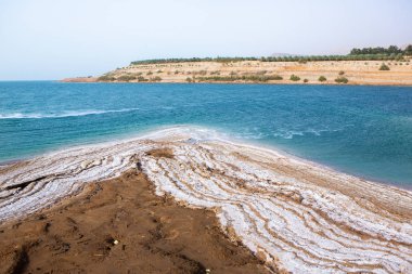 Ürdün 'de gün batımında Ölü Deniz kıyısı manzarası. Gün batımında tuz kristalleri. Mineral yapıları olan ölü deniz manzarası.