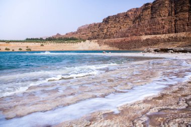 Ürdün 'de gün batımında Ölü Deniz kıyısı manzarası. Gün batımında tuz kristalleri. Mineral yapıları olan ölü deniz manzarası.