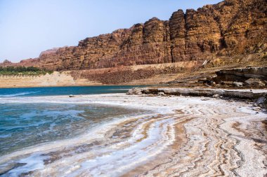 Ürdün 'de gün batımında Ölü Deniz kıyısı manzarası. Gün batımında tuz kristalleri. Mineral yapıları olan ölü deniz manzarası.