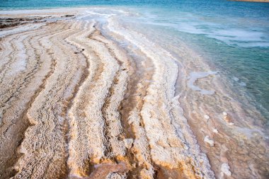 Ürdün 'de gün batımında Ölü Deniz kıyısı manzarası. Gün batımında tuz kristalleri. Mineral yapıları olan ölü deniz manzarası.