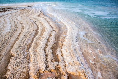 Ürdün 'de gün batımında Ölü Deniz kıyısı manzarası. Gün batımında tuz kristalleri. Mineral yapıları olan ölü deniz manzarası.
