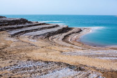 Ürdün 'de gün batımında Ölü Deniz kıyısı manzarası. Gün batımında tuz kristalleri. Mineral yapıları olan ölü deniz manzarası.