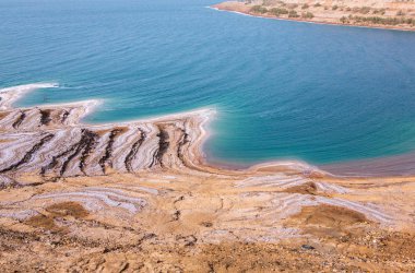 Ürdün 'de gün batımında Ölü Deniz kıyısı manzarası. Gün batımında tuz kristalleri. Mineral yapıları olan ölü deniz manzarası.