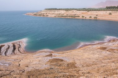 Ürdün 'de gün batımında Ölü Deniz kıyısı manzarası. Gün batımında tuz kristalleri. Mineral yapıları olan ölü deniz manzarası.