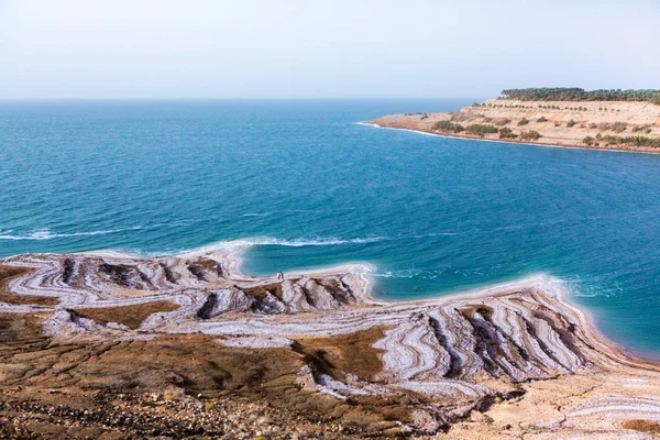 View of Dead Sea coastline at sunset time in Jordan. Salt crystals at sunset. Dead sea landscape with mineral structures.