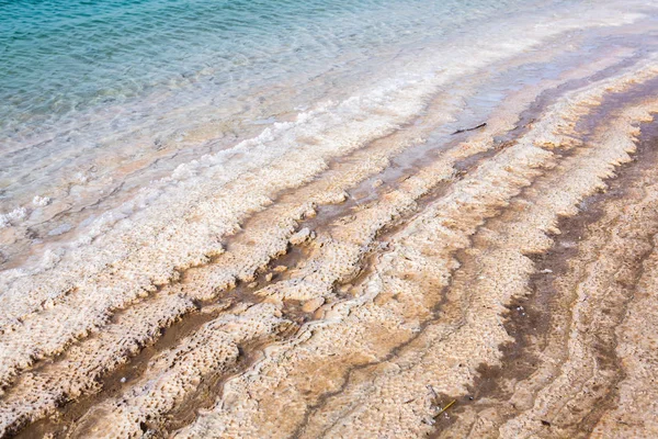 View of Dead Sea coastline at sunset time in Jordan. Salt crystals at sunset. Dead sea landscape with mineral structures.