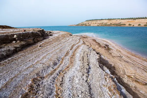 Ürdün 'de gün batımında Ölü Deniz kıyısı manzarası. Gün batımında tuz kristalleri. Mineral yapıları olan ölü deniz manzarası.