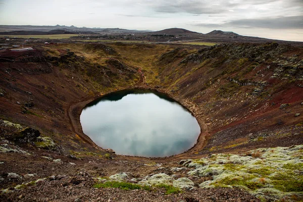 Kerid volcanic crater lake in Iceland. Landscape with red volcanic stones on the top of Kerid Crater with blue crater lake in Iceland