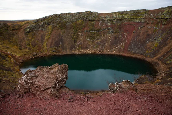 Kerid volcanic crater lake in Iceland. Landscape with red volcanic stones on the top of Kerid Crater with blue crater lake in Iceland