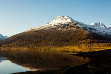 Renkli sonbahar doğası. İzlanda 'ya git. Dağları, gökyüzü ve bulutları olan güzel İzlanda manzarası.