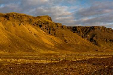 Renkli sonbahar doğası. İzlanda 'ya git. Dağları, gökyüzü ve bulutları olan güzel İzlanda manzarası.