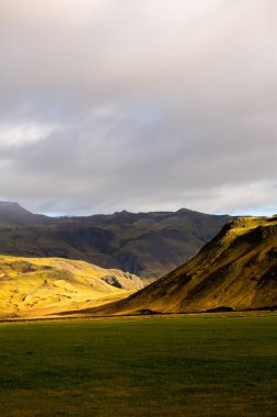 Renkli sonbahar doğası. İzlanda 'ya git. Dağları, gökyüzü ve bulutları olan güzel İzlanda manzarası.