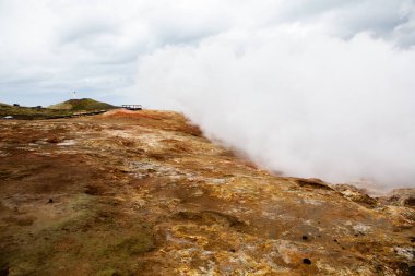 Renkli sonbahar doğası. İzlanda 'ya git. Dağları, gökyüzü ve bulutları olan güzel İzlanda manzarası.