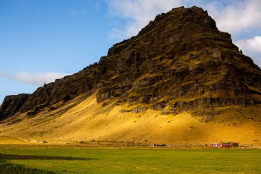Renkli sonbahar doğası. İzlanda 'ya git. Dağları, gökyüzü ve bulutları olan güzel İzlanda manzarası.