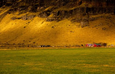 Renkli sonbahar doğası. İzlanda 'ya git. Dağları, gökyüzü ve bulutları olan güzel İzlanda manzarası.