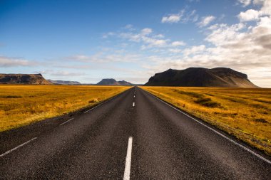 İzlanda 'ya giden yol. Yol ve araba manzaralı ve gün batımlı. Yolculuk konsepti. Araba yolculuğu macerası. Seyahat konsepti. Özgürlük.
