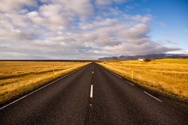 İzlanda 'ya giden yol. Yol ve araba manzaralı ve gün batımlı. Yolculuk konsepti. Araba yolculuğu macerası. Seyahat konsepti. Özgürlük.
