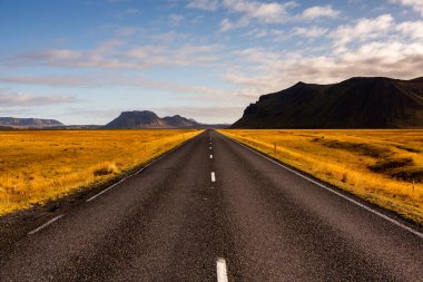 İzlanda 'ya giden yol. Yol ve araba manzaralı ve gün batımlı. Yolculuk konsepti. Araba yolculuğu macerası. Seyahat konsepti. Özgürlük.