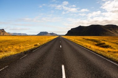 İzlanda 'ya giden yol. Yol ve araba manzaralı ve gün batımlı. Yolculuk konsepti. Araba yolculuğu macerası. Seyahat konsepti. Özgürlük.