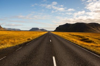 İzlanda 'ya giden yol. Yol ve araba manzaralı ve gün batımlı. Yolculuk konsepti. Araba yolculuğu macerası. Seyahat konsepti. Özgürlük.