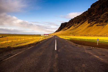 İzlanda 'ya giden yol. Yol ve araba manzaralı ve gün batımlı. Yolculuk konsepti. Araba yolculuğu macerası. Seyahat konsepti. Özgürlük.