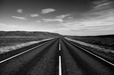İzlanda 'ya giden yol. Yol ve araba manzaralı ve gün batımlı. Yolculuk konsepti. Araba yolculuğu macerası. Seyahat konsepti. Özgürlük.