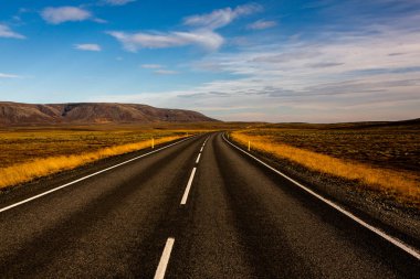 İzlanda 'ya giden yol. Yol ve araba manzaralı ve gün batımlı. Yolculuk konsepti. Araba yolculuğu macerası. Seyahat konsepti. Özgürlük.