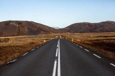 İzlanda 'ya giden yol. Yol ve araba manzaralı ve gün batımlı. Yolculuk konsepti. Araba yolculuğu macerası. Seyahat konsepti. Özgürlük.