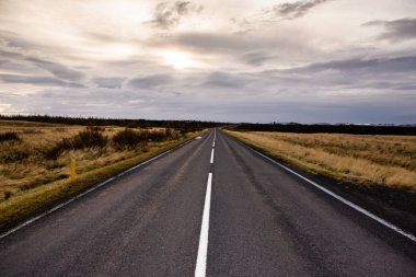 İzlanda 'ya giden yol. Yol ve araba manzaralı ve gün batımlı. Yolculuk konsepti. Araba yolculuğu macerası. Seyahat konsepti. Özgürlük.