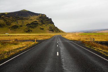 İzlanda 'ya giden yol. Yol ve araba manzaralı ve gün batımlı. Yolculuk konsepti. Araba yolculuğu macerası. Seyahat konsepti. Özgürlük.