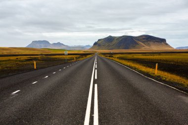 İzlanda 'ya giden yol. Yol ve araba manzaralı ve gün batımlı. Yolculuk konsepti. Araba yolculuğu macerası. Seyahat konsepti. Özgürlük.