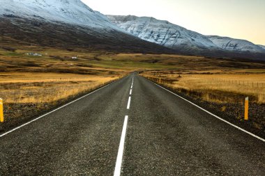 İzlanda 'ya giden yol. Yol ve araba manzaralı ve gün batımlı. Yolculuk konsepti. Araba yolculuğu macerası. Seyahat konsepti. Özgürlük.