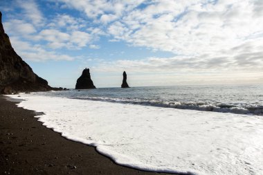 Görüntü siyah kum plaj yakınındaki South Coast İzlanda, Vik. Beyaz Köpük Güney İzlanda bir siyah lav plajda. Konumlar ve İzlanda doğası.